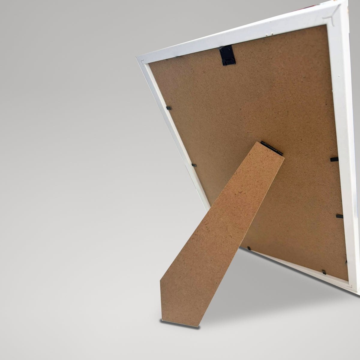 Back of the white frame with its fold-out easel stand and hanger